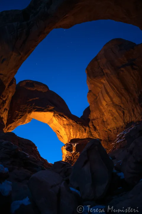 Double Arch lit from below at blue hour, Arches National Park