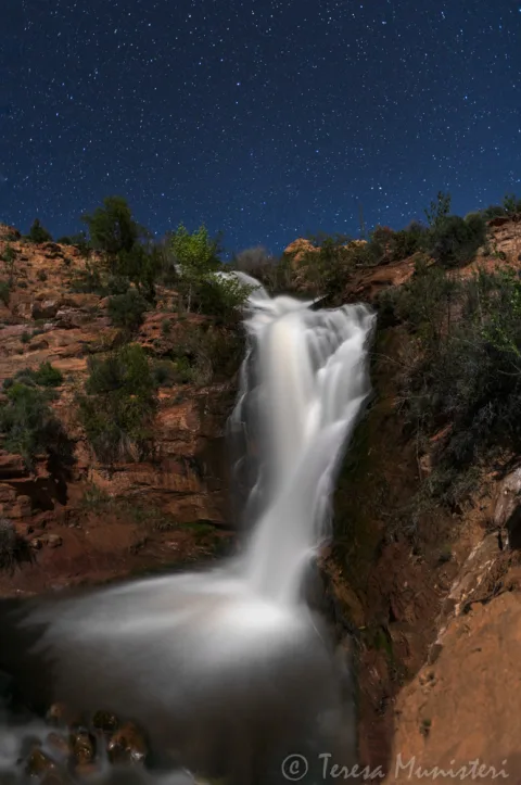 Long exposure of a desert waterfall under a starry sky