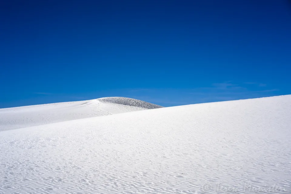 A white gypsum dune against a deep blue sky, White Sands