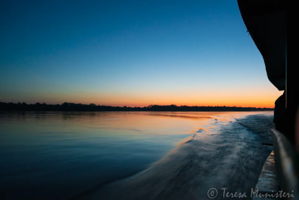 Dawn over a river beach from beneath a rock overhang