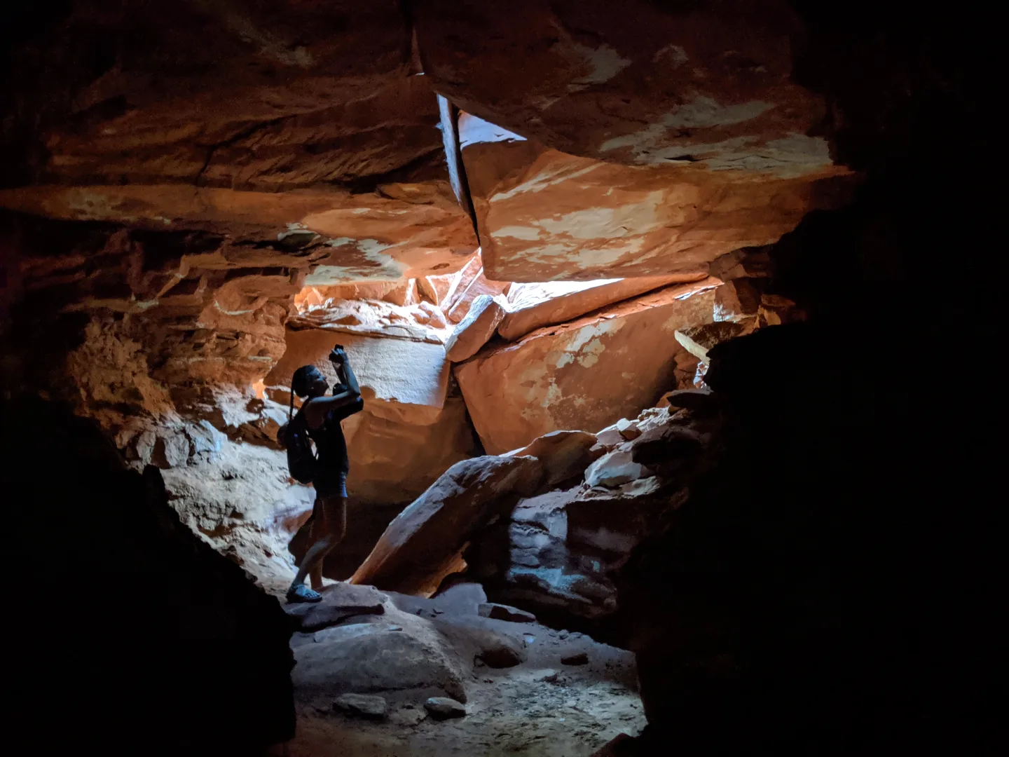 Daylight entering a sandstone cave over fallen slabs